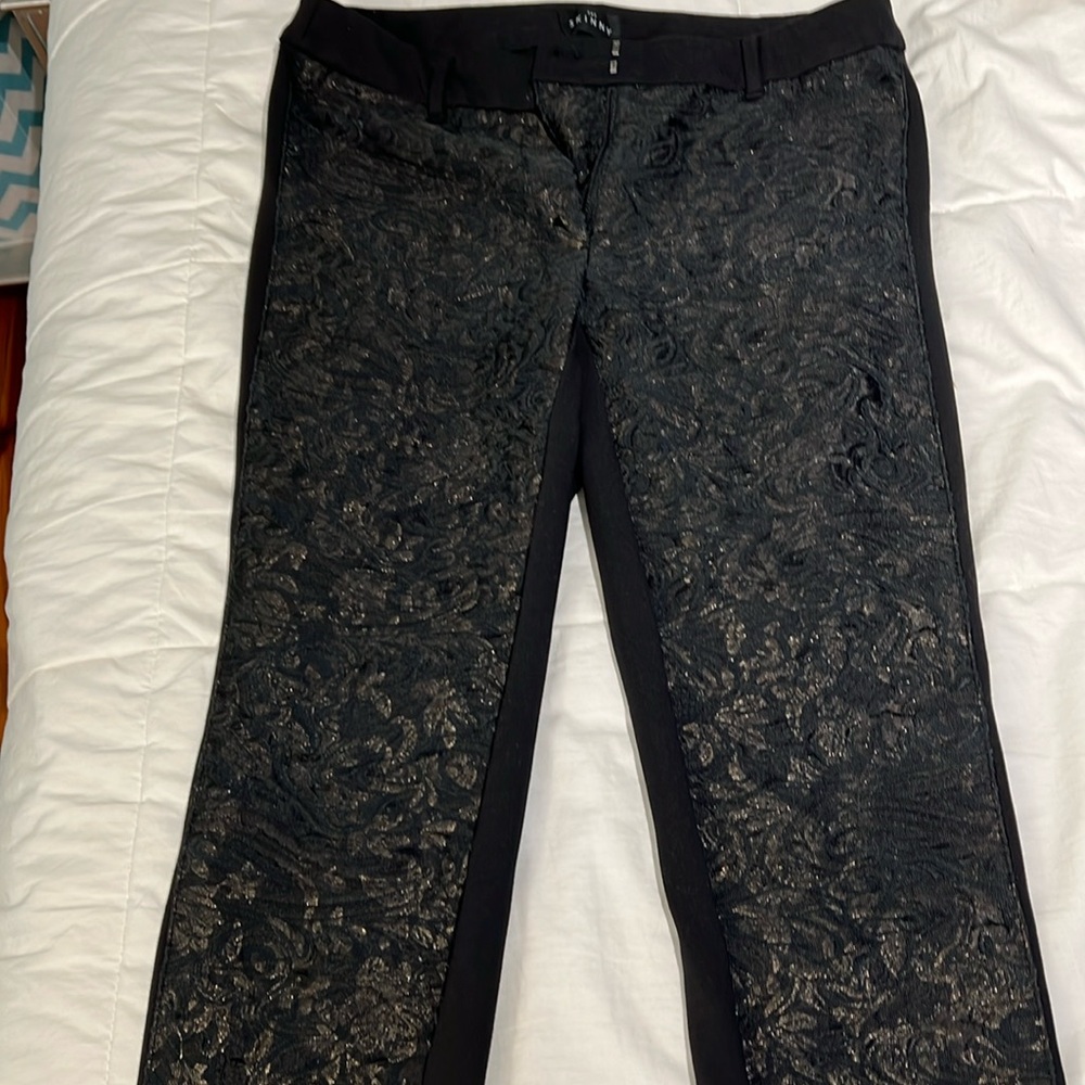Black leggings with gold detail on the front .
